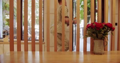 Man Carries Dessert in Bright Cafe