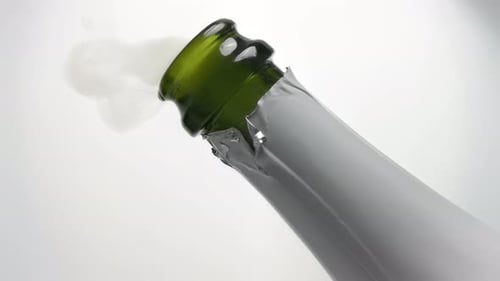 Champagne Pouring Out Of White Labeled Bottle