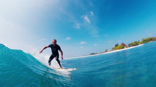 Man Surfs Ocean Wave in the Maldives