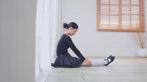 Woman Stretches in Leotard and Ballet Skirt