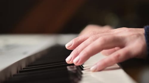 Woman's Hand Playing Piano Keys Close Up