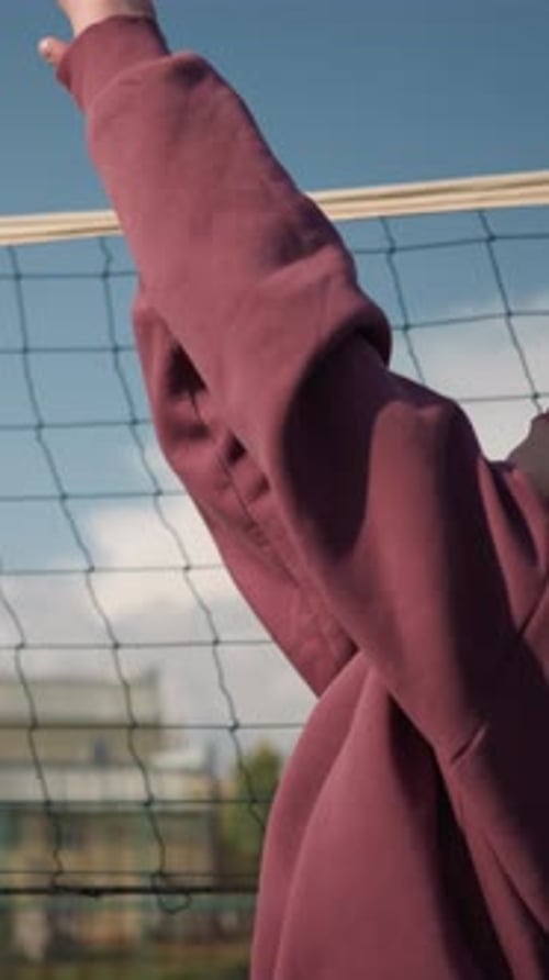 Teen Girl Looking up at Volleyball Net Outdoors