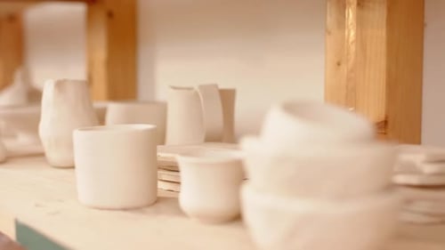 Ceramic products lying on shelf in pottery studio
