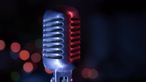 Vintage retro microphone on stage against dark background with lights close-up