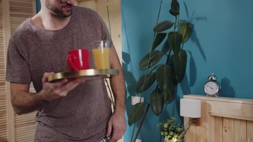 Man Brings Breakfast in Bed to Woman