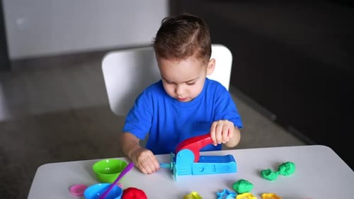 Cute Child Playing with Colorful Dough at Table