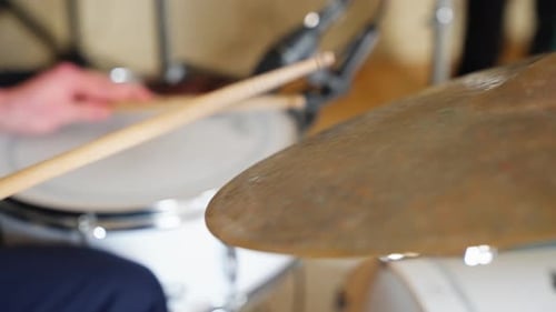 Drumsticks bounce off snare and cymbals in slow motion