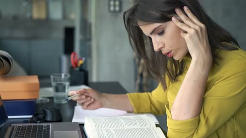 Young Creative Businesswoman Reading Book and Writing Notes at Home Office Adult