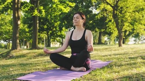 Woman Meditating Outdoors in Peaceful Green Park