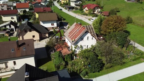 Construction Workers Replacing Roof Tiles on Suburban Home