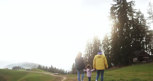 Young family doing trekking on alps mountain during summer time - Travel concept