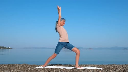 Mädchen Virabhadrasana an der Küste