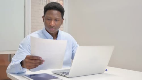 Excited Man Reads Paper in Office Setting