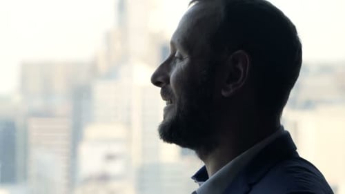Young Businessman Drinking Coffee and Admire View Standing by Window in Office 30s