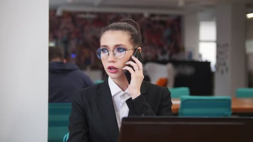 Businesswoman Talking on Phone in Modern Workspace