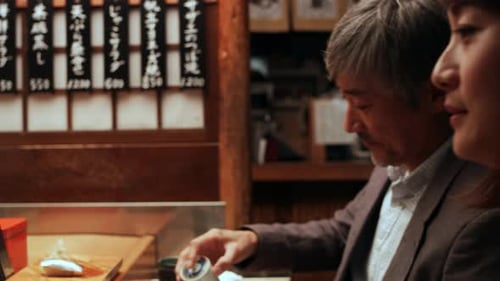 Couple Drinking Tea and Eating Sushi at Restaurant
