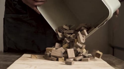 Woodworker Pours Blocks onto Board Indoors
