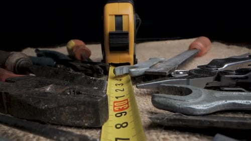 CloseUp View of Various Tools and a Tape Measure on a Fabric Surface