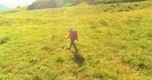 Flight Over Backpack Hiking Tourist Walking Across Green Mountain Field Huge Rural Valley at Summer