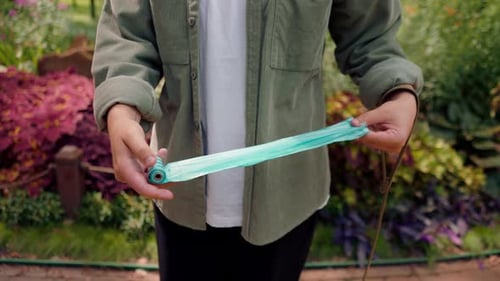 bolsa de basura femenina de cerca sujetando bolsas de basura para limpiar después del cuidado de animales de una mascota en el parque