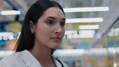 CloseUp View Of A Woman Standing And Looking At Products Thinking About What To Choose