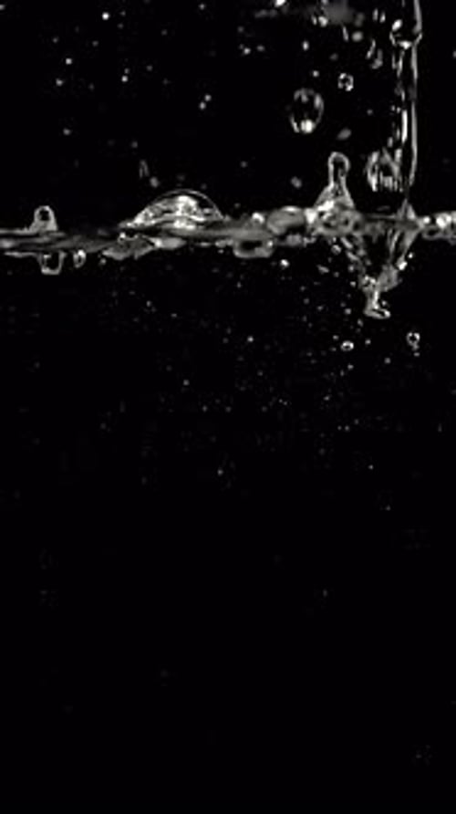 Water Droplets Splashing Against Black Background in Slow Motion