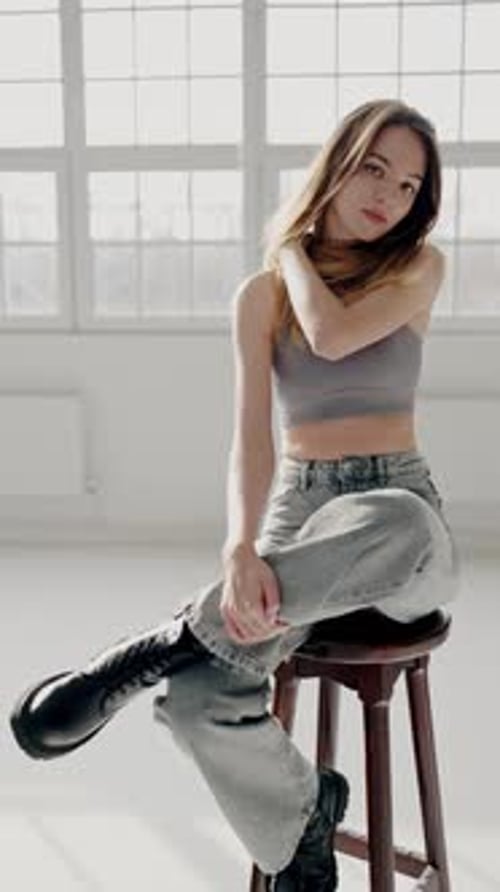 Stylish Young Woman in Casual Clothes Posing in Bright Room