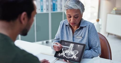 Doctor Reviews X-Ray with Patient on Tablet