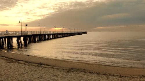 Beautiful aerial shot sunrise by the sea. A calm sea with smooth waves. Orange sky and clouds in the