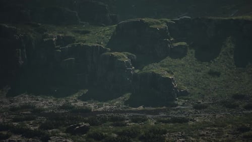 A Mountain Range with Rocks and Grass in the Foreground