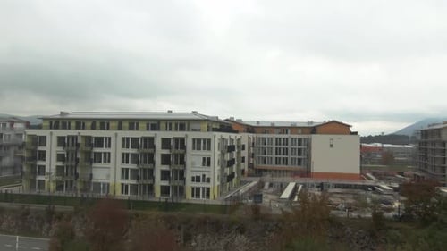 Drohnen schossen über einige Wohnhäuser, in der Nähe gibt es eine Baustelle und einen Kran. Fliegend t