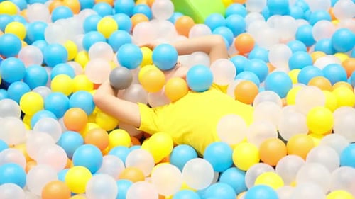 Boy Playing in Playground Colourful Ball Pool Happiness in Bright Colors