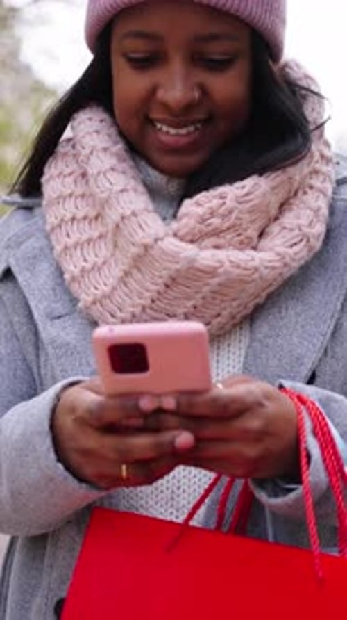 Smiling young adult using a cell phone