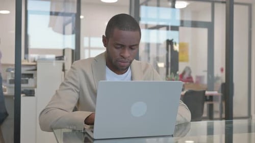 African Businessman Working on Laptop in Office
