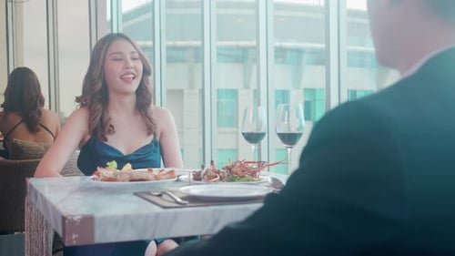 Happy young couple holding with glass of wine cheer together in anniversary at restaurant.