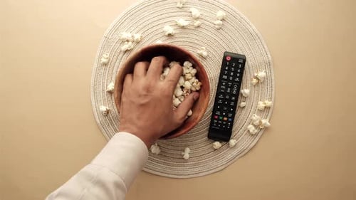 High Angle View of Men Hand Picking Popcorn and Using Tv Remote