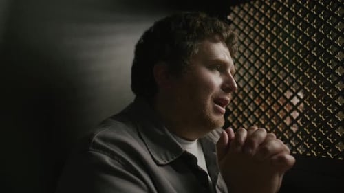 Man Praying in a Confessional Booth with Faith