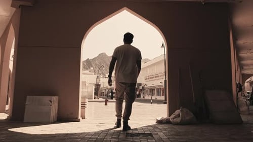 Wide Shot of Person Walking and Looking at Mutrah Mountains and Market, Oman