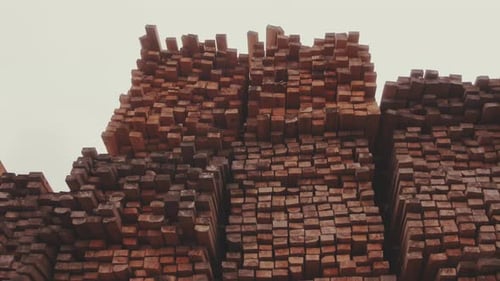 Stacked Lumber at a Lumberyard Under Gray Sky