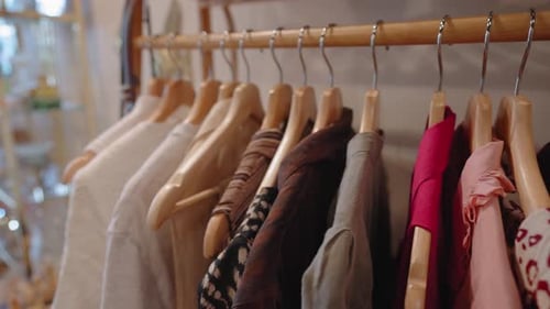Clothes on a clothing rack at a thrift store. Second hand clothes for sale at a thrift store. Clothe