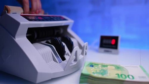 Money Counter Counting Euro Banknotes on a White Table