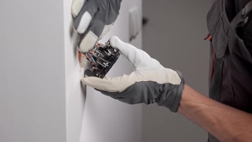 Electrician installing electrical outlet in the wall
