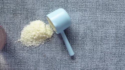 Close Up of Baby Milk Powder and Spoon on Tile Background