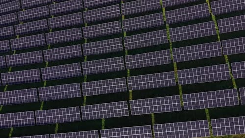 Solar panels arranged in rows on a sunny day in a renewable energy field
