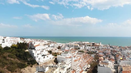 Sea view and white cityscape of Albufeira, In Algarve, Portugal - Wide Reveal Aerial Shot