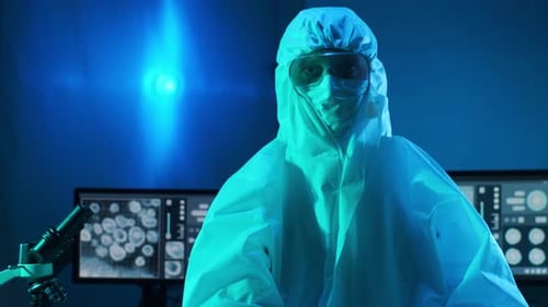 Scientist Removes Protective Gear in Blue Lab Setting