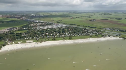 Aerial view of people doing kite surfing along the beach sunny day, Netherlands