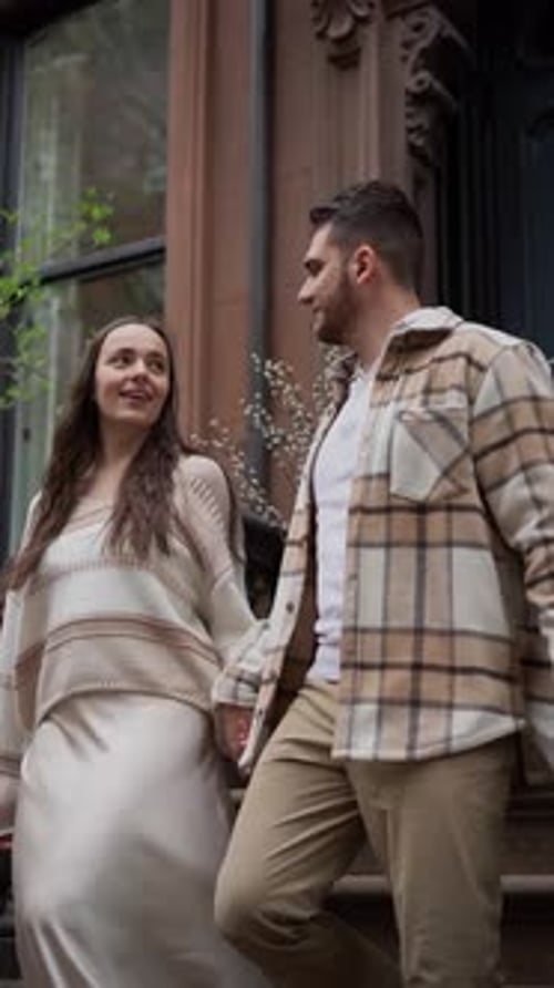 Paar sitzt auf den Stufen des Brownstone-Gebäudes und genießt die Gesellschaft des anderen
