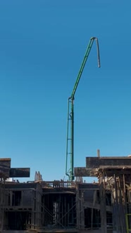 Vertical Video of Engineers Supervising Workers and a Crane Assisting in Foundation and Wall
