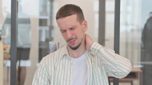 Young Man Experiencing Neck Pain in the Office